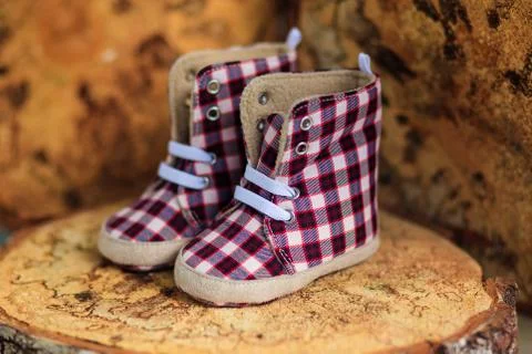 Children's checkered pattern with the shoes stand on a wooden stump 스톡 사진