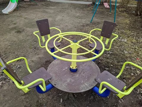 Children's circular carousel on the playground in the spring Stock Photos