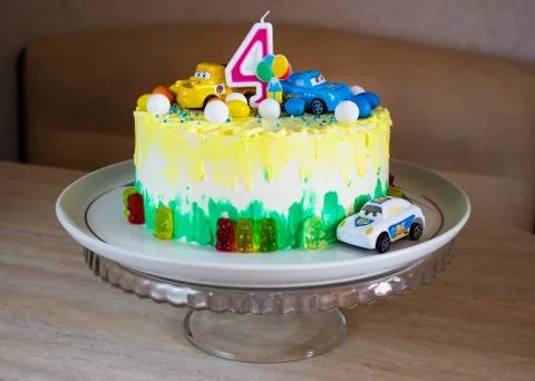 Children's colorful fondant birthday cake decorated with little cars Stock Photos