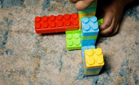 Childrens Creative Play With Multicolored Building Blocks and Toy Figure Stock Photos
