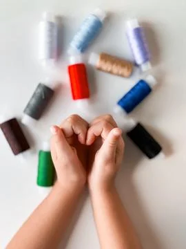 Childrens creativity with colorful sewing threads and playful hands Stock Photos