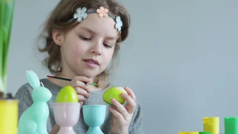 Children's creativity, the girl paints Easter eggs, smeared her fingers in paint Stock Footage 103361986