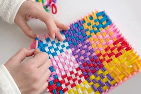 Childrens creativity weaving with colored threads ropes Stock Photos