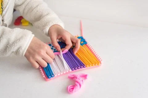 Childrens creativity weaving with colored threads ropes Stock Photos