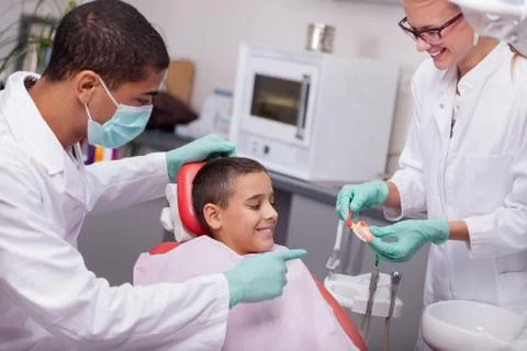 Children's dentist explains to the child how to properly wash their teeth Stock Photos