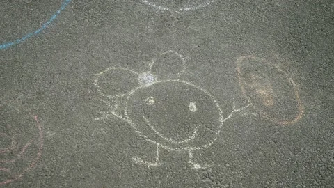 Children's drawing with colored chalk on gray asphalt, smiley face with balloon Vídeos de archivo 170940252