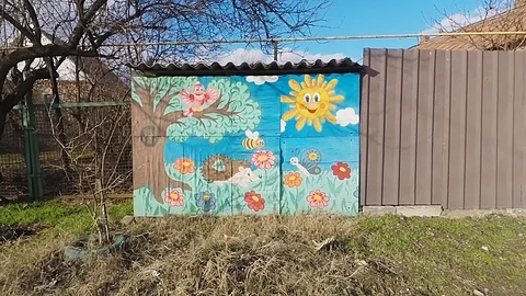 Children's drawing on the wall of the barn, sun flowers, trees clouds Stock Footage 124167413
