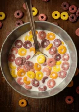 Children's dry multi-colored flakes with milk on a wooden table Stock Photos