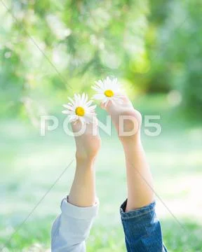 Children`s feet with flowers Stock Photos