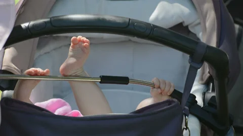 Children's feet in the stroller Stock Footage 27570272