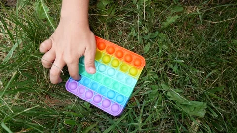 Children's hand presses the bubbles in the pop-it toy Video stock 166880356