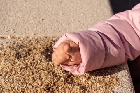 Children's hand takes a handful of sand Stock Photos