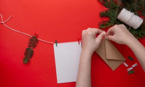 Children's hands attaches an envelope to a string with a Christmas gift Stock Photos