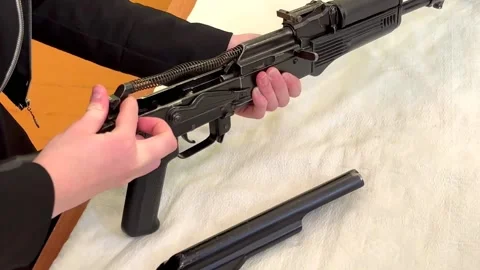 Children's hands cannot insert the spring into the machine. weapon assembly Video stock 232792318