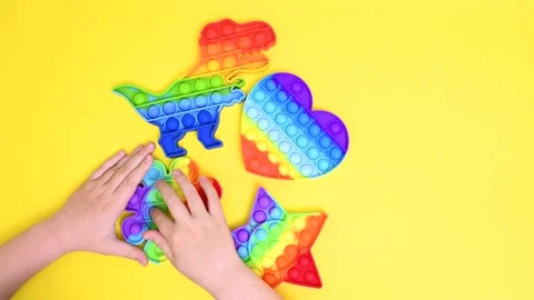 Children's hands close-up playing with a rubber multi-colored pop it toy Stock-Footage 155002701