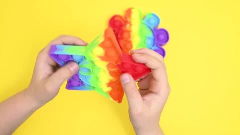 Children's hands close-up playing with a rubber multi-colored pop it toy Stock-Footage 155002746