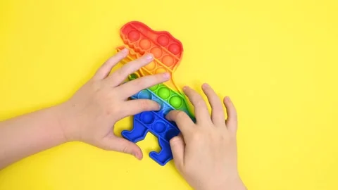 Children's hands close-up playing with a rubber multi-colored pop it toy 库存影片 155002794
