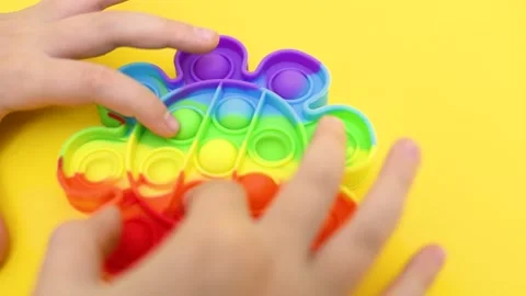 Children's hands close-up playing with a rubber multi-colored pop it toy Stock-Footage 155002895