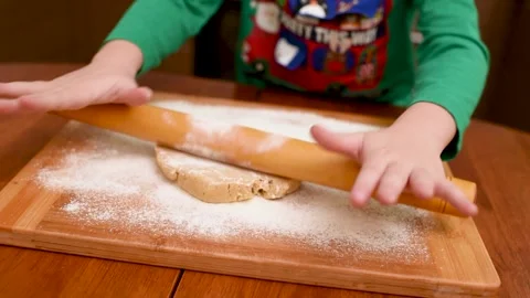 Children's hands close-up roll out the dough for gingerbread with a wooden Stock-Footage 142280703