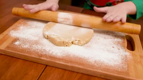 Children's hands close-up roll out the dough for gingerbread with a wooden Stock-Footage 142280733