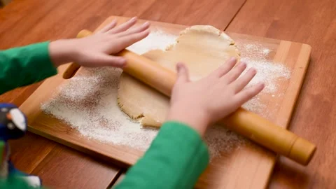 Children's hands close-up roll out the dough for gingerbread with a wooden Stock-Footage 142280758