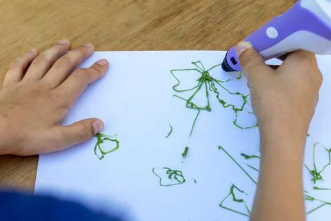 Children's hands create figures with 3D pen. Close-up. Top view Stock Photos