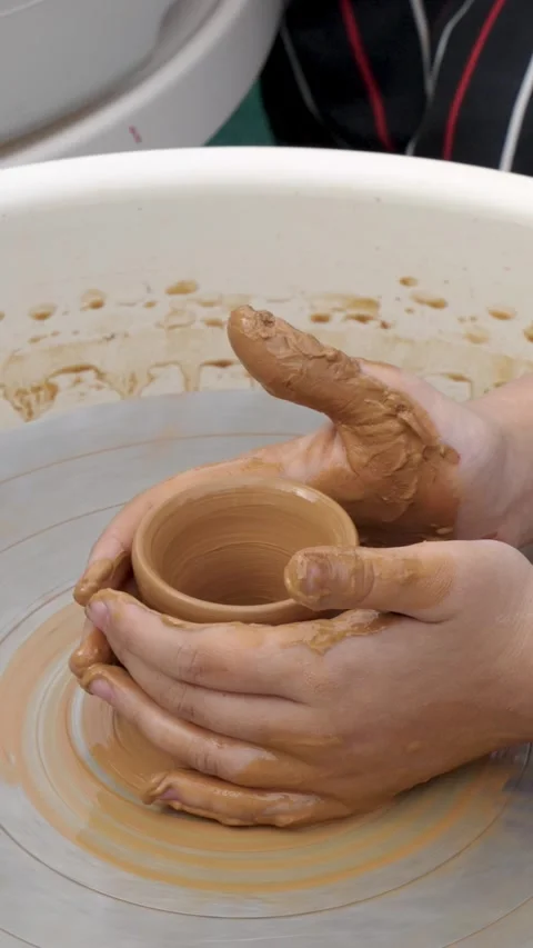 Children's hands create pottery on a potter's wheel during a master class Stock Footage 274897673