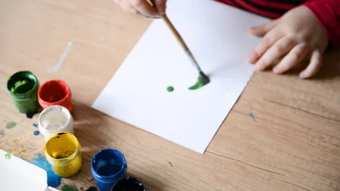 Children's hands draw green circle watercolors on surface of wooden table on Stock Footage 104881824