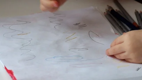 Children's hands draw multicolored doodles on a piece of paper Stock Footage 86110448