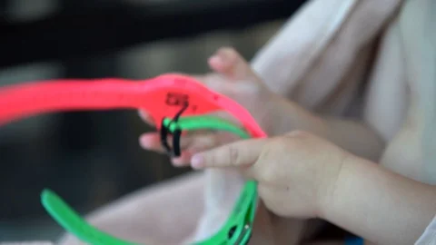 Children's hands holding two bracelets with locker keys in the locker room pink  Stock Footage 108985304
