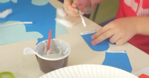 Children's Hands Kid is Making a Paper Applique Educator Helps Him Putting a Stock Footage 58479561