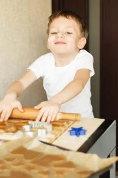 Children's hands make gingerbread. Small boy cutting cookies for Christmas. K Stock Photos
