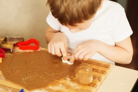 Children's hands make gingerbread. Small boy cutting cookies for Christmas. K Stock Photos