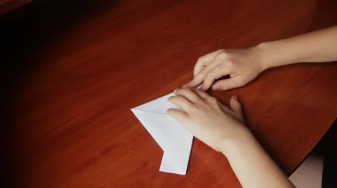 Children's hands making origami ship Stock Footage