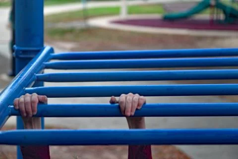 Children's hands on monkey bars Stock Photos