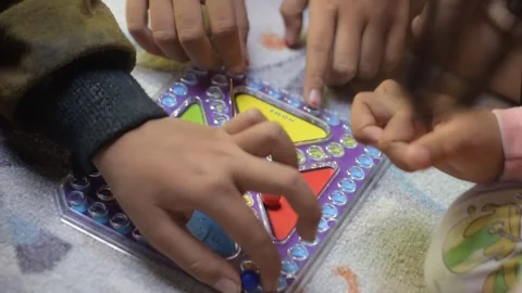 Children's hands move balls across a board game Stock Footage 289542774