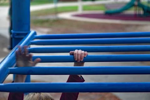 Children's hands moving on monkey bars Stock Photos