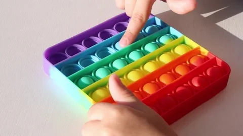 Children's hands press the colorful bubbles of the toy. Stock Footage 154906108