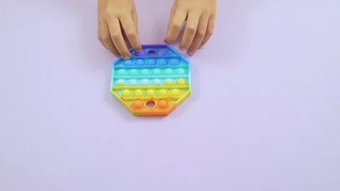Children's hands presses bubbles on modern silicone toy pop it. Stock Footage 162130988