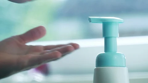 Children's hands push the dispenser and squeeze out liquid soap Stock Footage 114770319