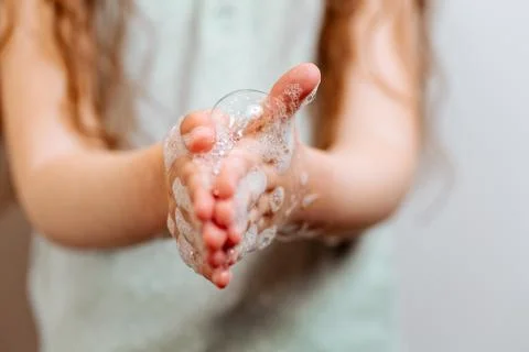 Children's hands in soapy foam. Stock Photos