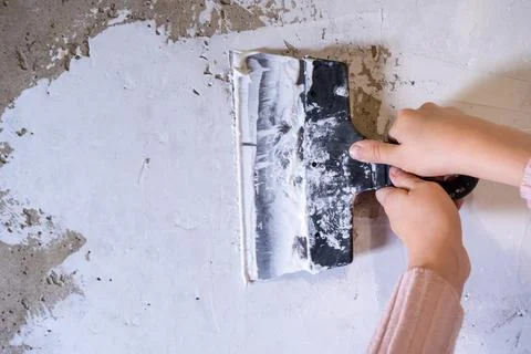 Children's hands work with a spatula. Alignment of walls, finishing works Stock Photos