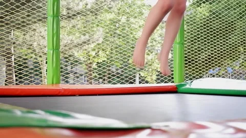 Children's legs jumping high on trampoline Stock Footage 340131111