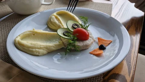 Children's menu. The child eats mashed potatoes and a rabbit cutlet. Stock Footage 220007001