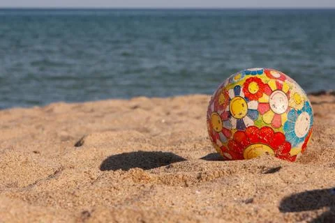 Children's multi-colored ball on the beach Stock Photos