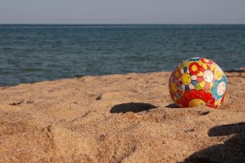 Children's multi-colored ball on the beach Stock Photos