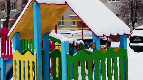 Childrens multi-colored playhouse with a cap of snow on the playground in winter Stock Footage 291776326