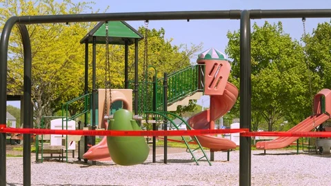 Children's playground closed off with red caution tape Video stock 129469974