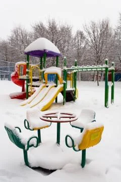 Children's playground is covered with a thick layer of snow. Stock Photos