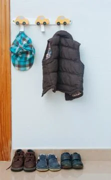 In the children's room on the hanger hangs a jacket and there are d shoes Stock Photos